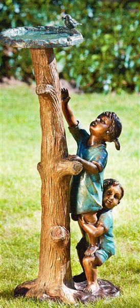 Kinder am Baumstamm mit Vogeltränke