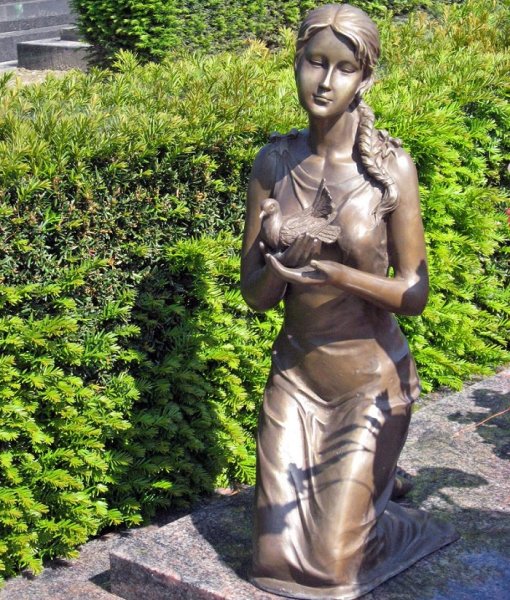 Mädchen kniend mit Taube aus Bronze