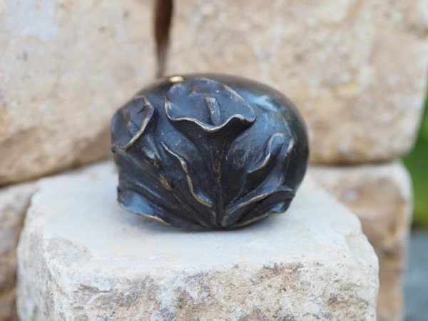Bronzestein mit Blütenverzierung