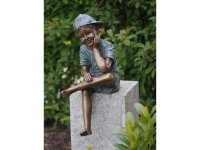 Bronzeskulptur lächelnder sitzender Junge mit Basecap