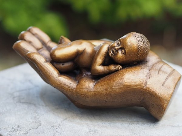 Bronzefigur schlafendes Baby in einer Hand