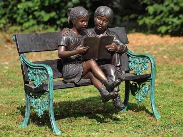 Bronzeskulptur Junge und Mädchen beim Lesen auf einer Bank