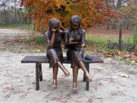 Bronzeskulptur zwei Mädchen beim Lesen auf einer Bank